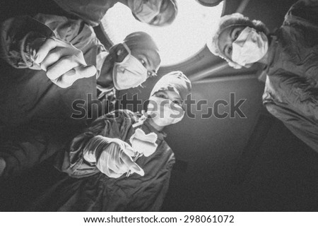 Surgeons team standing above of the patient before surgery. , Black and white,noise and film grain style