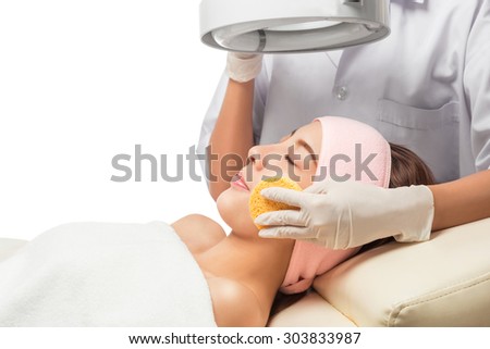 Peaceful brunette getting micro dermabrasion from beauty therapist in the health spa. isolated on white with clipping path.