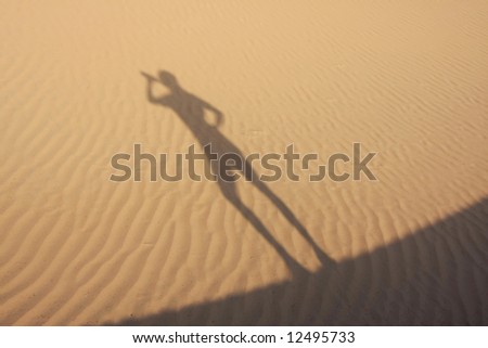 Shadow in dunes with playful figure