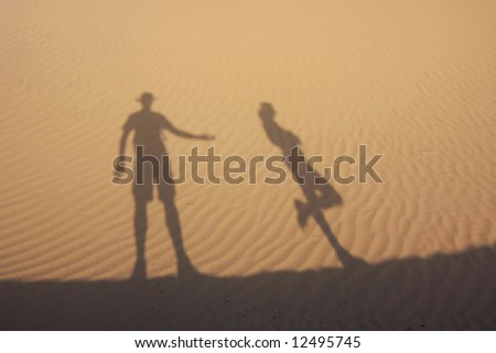 Shadow in dunes with thirsty man