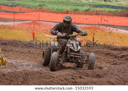 Quad bike in racing track. A lot of dirt and mud