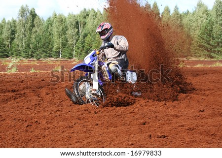 Off-road motorbike extreme cornering in dirt. A lot of flying dirt.
