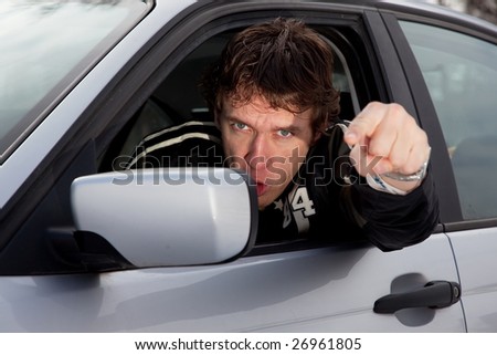 Aggressive driver concept, young man driving aggressively