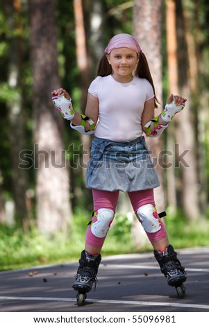 Girl riding rollerblades on skating track in a park