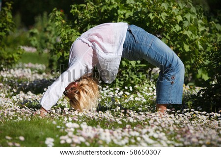 Young girl doing back-bend in garden