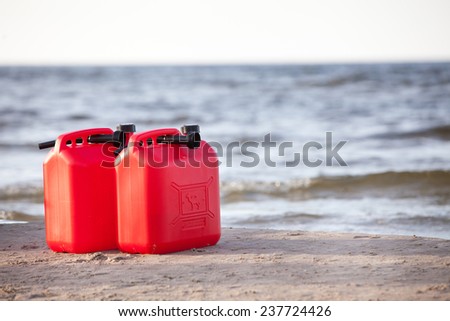 Two red fuel cans on the beach