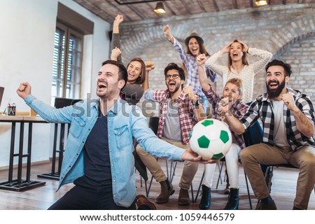 Happy friends or football fans watching soccer on tv and celebrating victory. Friendship, sports and entertainment concept.