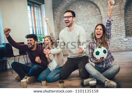 Happy friends or football fans watching soccer on tv and celebrating victory. Friendship, sports and entertainment concept.