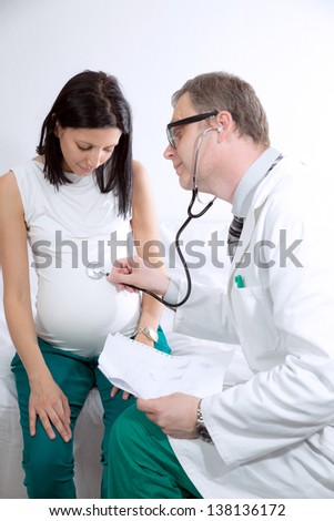 Doctor concentrating on pregnancy examination with stethoscope