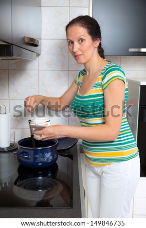 women cook lunch in a saucepan and salt dish by hand