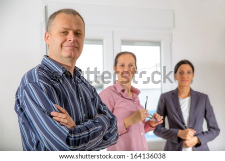 Young colleagues, one man, two women standing