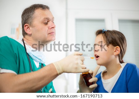 Cute little girl visiting pediatrician and taking medicine
