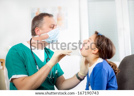 Pediatrician checking little girl throat