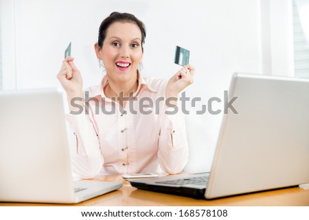 Smiling corporate woman showing her cash card  and credit card to the camera.