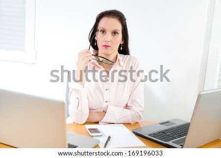 Portrait of a businesswoman with lots of work at office desk