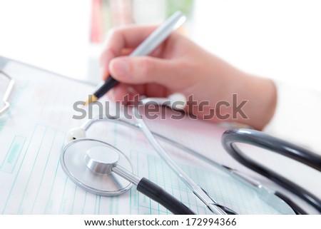 Doctor hand writing a medical recipe