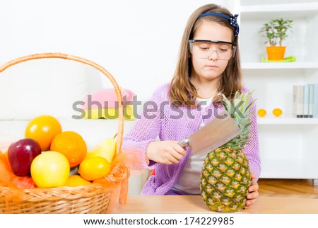 Little girl with meat chopper and pineapple
