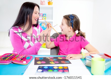 Mother  and daughter painting and having fun.