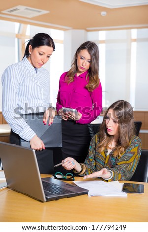 Three attractive female colleagues working in the office