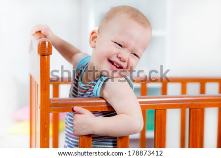 Baby boy standing in crib