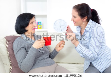 Caring for the elderly. Adult woman giving medicament to mature mother at home