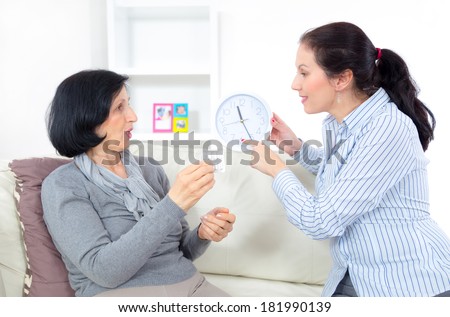 Caring for the elderly. Adult woman giving medicament to mature mother at home