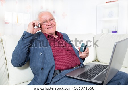Man indoors using telephone and looking at credit card