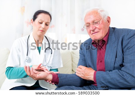 Young doctor checking senior patient blood pressure