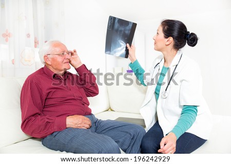 Home Care. Doctor showing x-ray to senior man