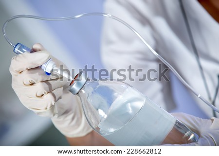 Nurse prepares IV solution for infusion.