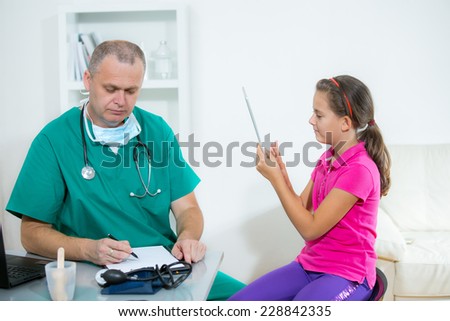 Little girl in a doctor\'s office using tablet pc
