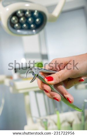 Doctor holding pliers for pulling out the tooth.