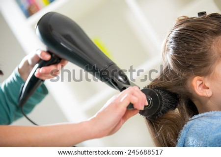 Mother dries hair teenage girl
