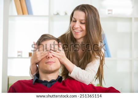 Woman puts his hand over his eyes a man to make him a surprise.Selective focus