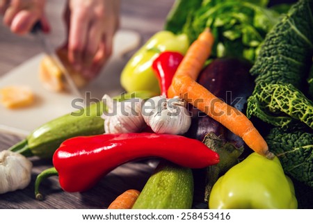 Vegetables On Wooden Background. Woman cut vegetables and prepare it for cooking