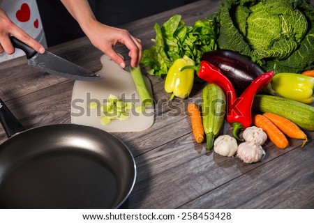 Vegetables On Wooden Background. Woman cut vegetables and prepare it for cooking