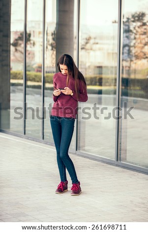 Teen using cell phone. Young woman looking at a smartphone