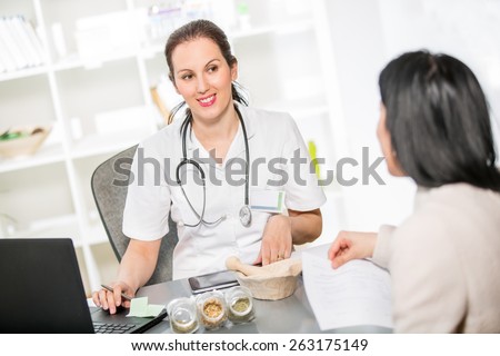 Alternative Medicine - Homeopathy.Young woman in an office at the doctor homeopaths.  Treatment with herbs.