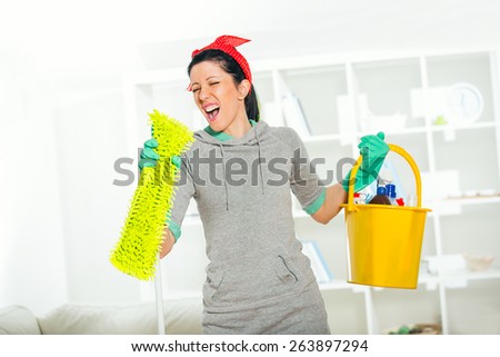 Funny woman mopping floor and singing