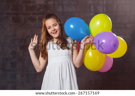 Ten year old caucasian girl with long hair posing in the studio with ballons