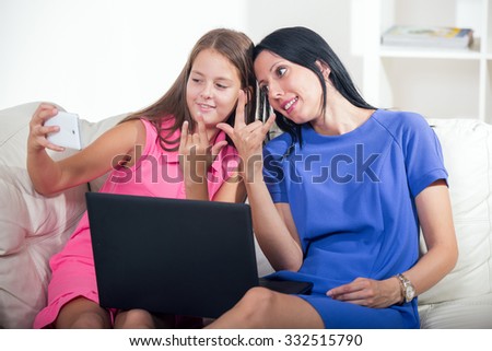 Smiling deaf woman and child talking using sign language on the smartphone's cam