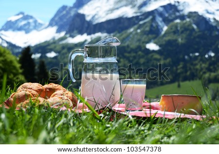 Milk, cheese and bread against Alpine scenery