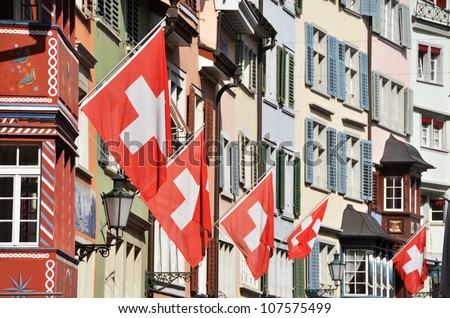 Old street in Zurich decorated with flags for the Swiss National Day, 1st of August