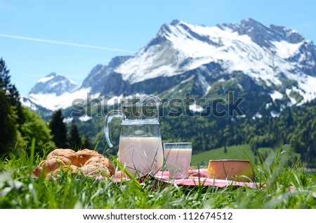 Milk, cheese and bread served at a picnic on Alpine meadow, Switzerland