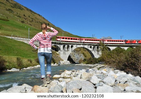 Girl looking at the train, which crosses a bridge. Switzerland