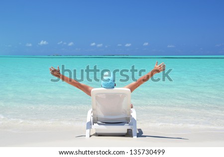 A young man sunbathing on the beach of Exuma, Bahamas