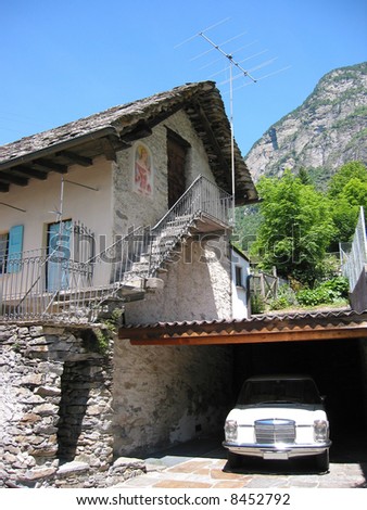 Traditional italian stone house and a retro car in the garage