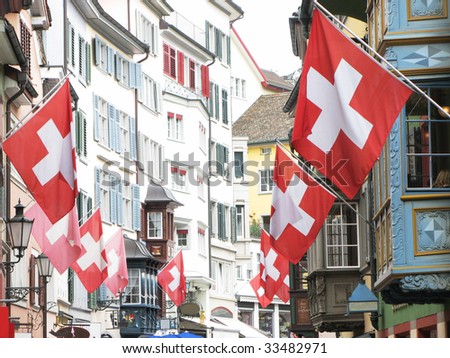 Old street in Zurich decorated with flags for the Swiss National Day