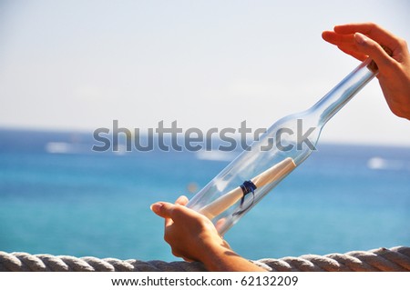 Bottle with a message in the hands
