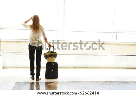 Girl at the airport window looking to the ocean